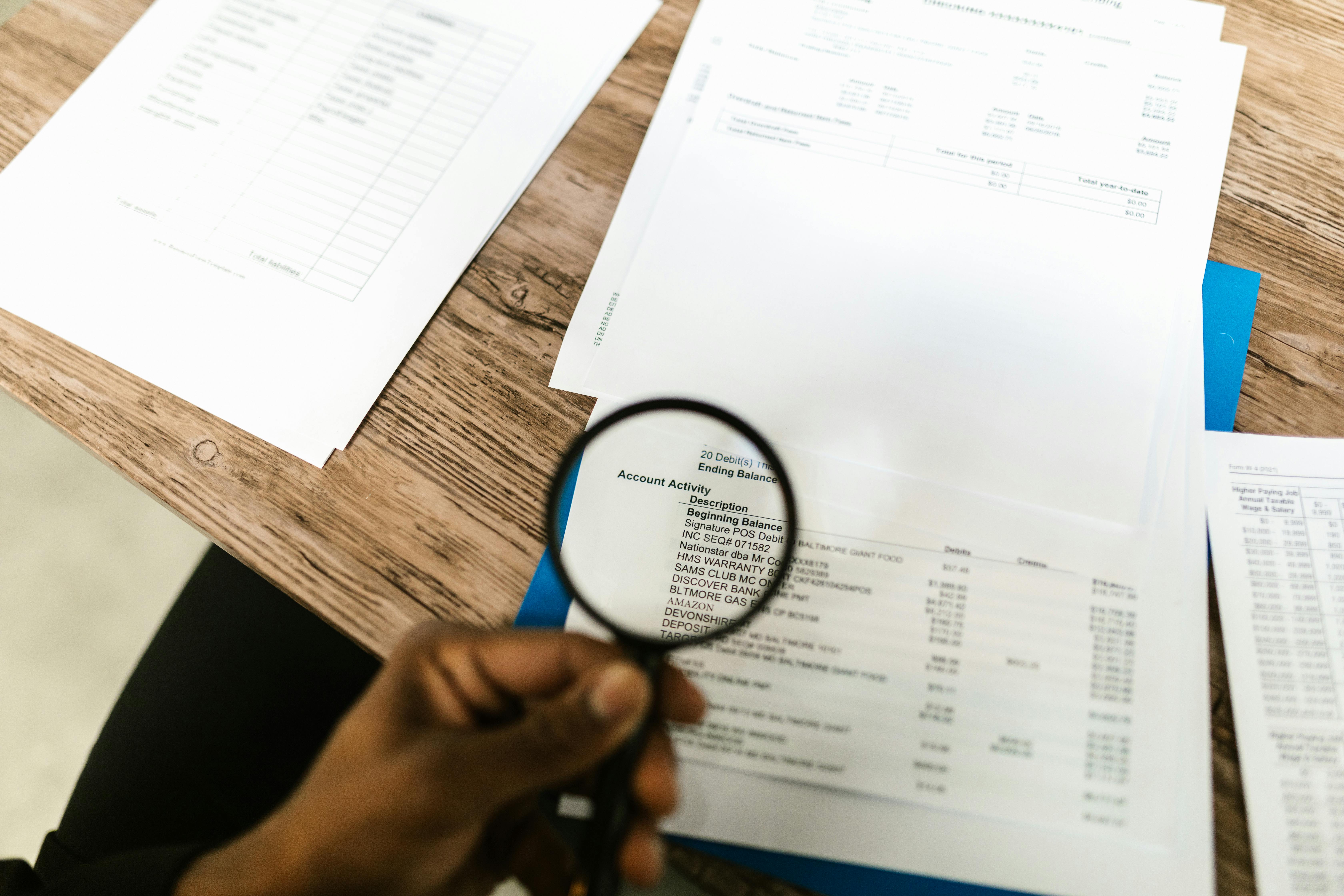 Detailed document review with a magnifying glass during an audit